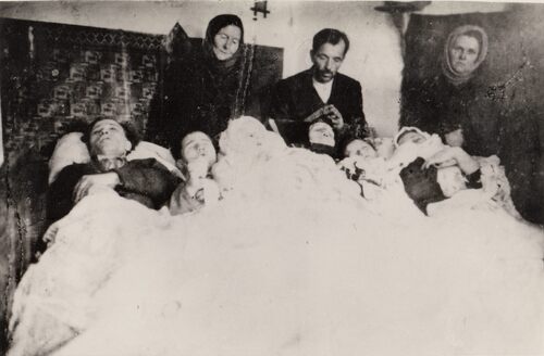 Na łóżku leży sześć ofiar morderstwa - członków rodziny Stanisława Karpiaka, zamordowanych przez bandy ukraińskie 14 grudnia 1943 roku we wsi Latacz (województwo tarnopolskie). Ofiary przykryte są kołdrą. Na łóżku spoczywają ciała: żony Marii (trzecia z prawej), córek Zofii (druga z prawej) i Genowefy (pierwsza z prawej), synów: Józefa (pierwszy z lewej), Władysława (drygi z lewej) i Zygmunta (trzeci z lewej). Przy łóżku między dwoma kobietami stoi Stanisław Karpiak - ojciec rodziny.